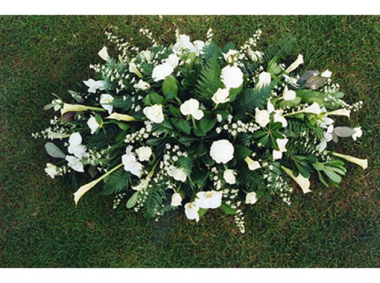 Langwerpig bloemstuk met witte rozen en witte orchideeën
